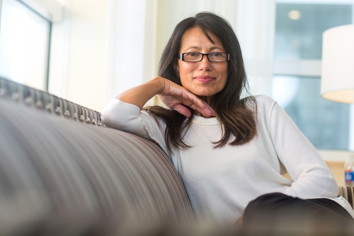 Mature woman sitting on the sofa wearing glasses