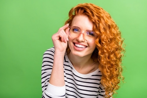 woman wear striped shirt arm spectacles smiling