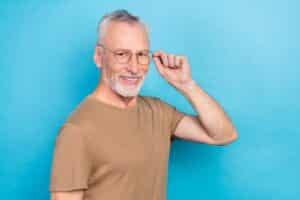 Photo of good looking senior man holding and wear eyeglasses